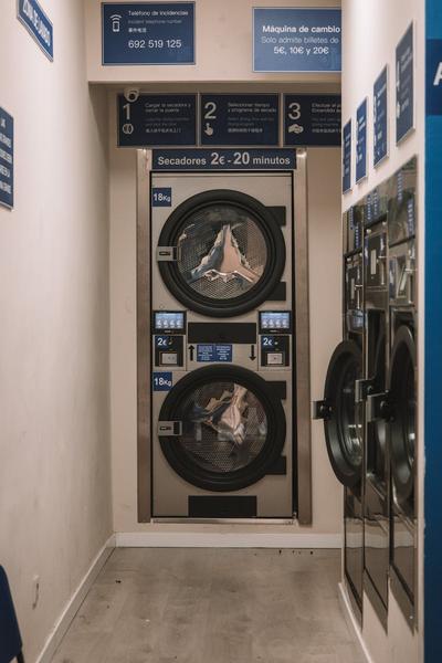 Interior view of a laundromat in Valencia, Spain with industrial washing machines.