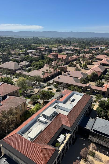 High-angle shot of Stanford University's distinctive red-roofed buildings and surrounding landscape.