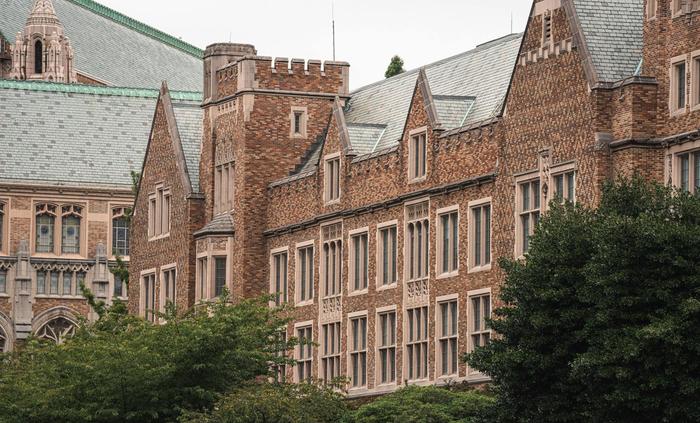 View of historic brick building with slate roofs and Gothic architectural features.